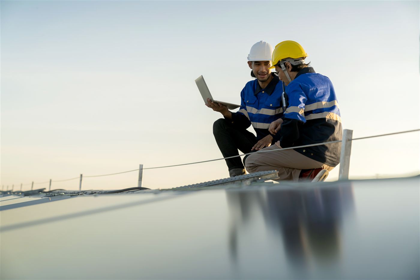 Technician installing solar panel on rooftop